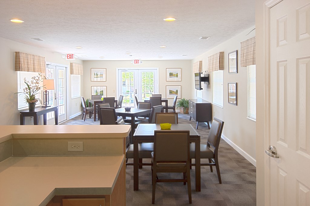 a dining room with tables and chairs and a kitchen