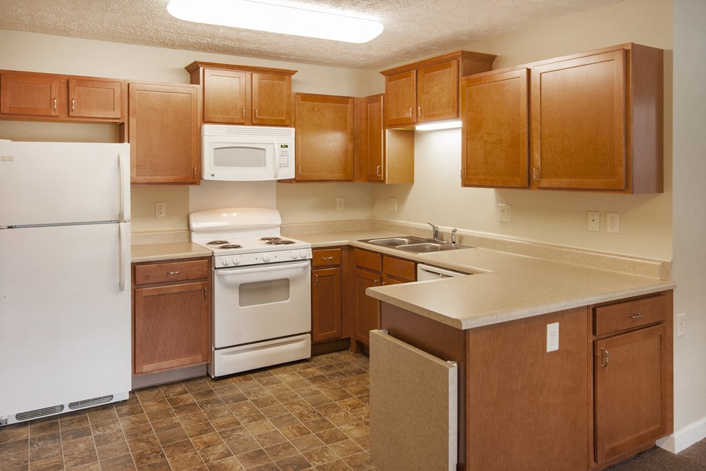 a kitchen with white appliances and wooden cabinets