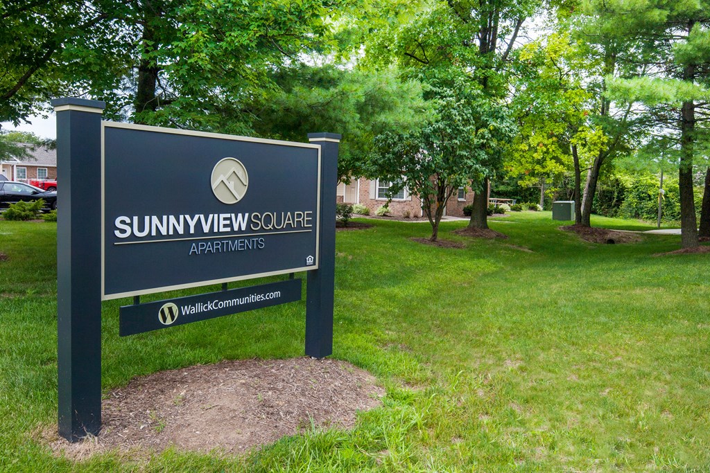 a park with a sign that reads sunview college apartments