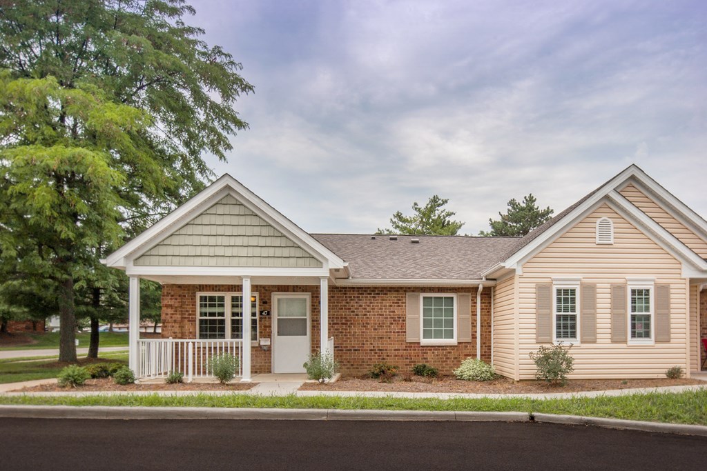 a small house with a porch and a street in front of it