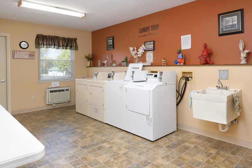 the laundry room is equipped with washer and dryers and a sink