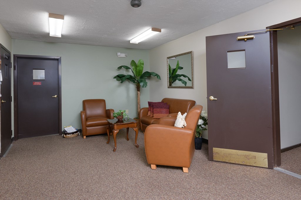 a waiting room with chairs and a table and a door