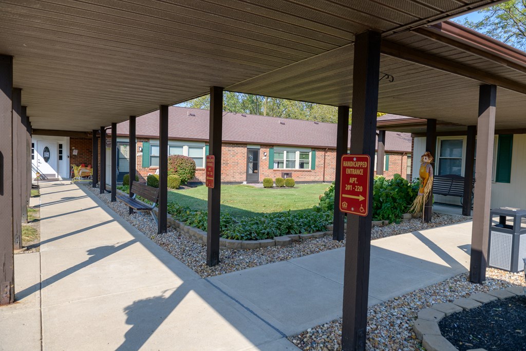 a covered walkway with a red sign in front of a building