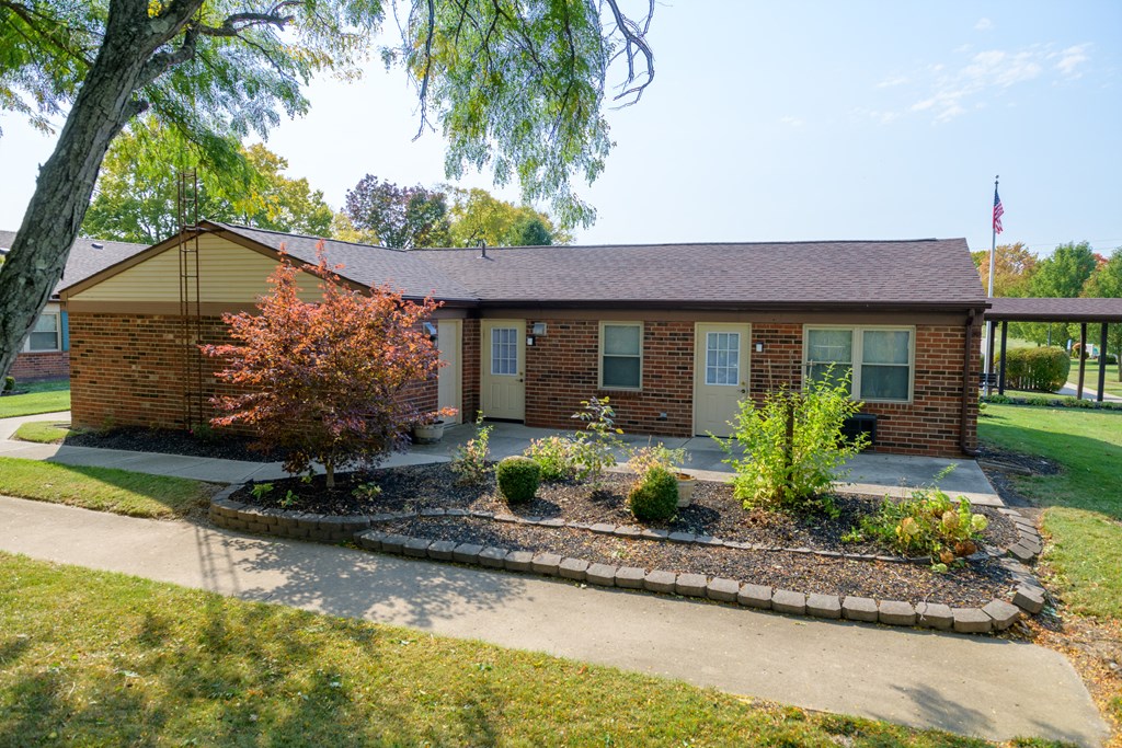 a small brick house with a garden in front of it