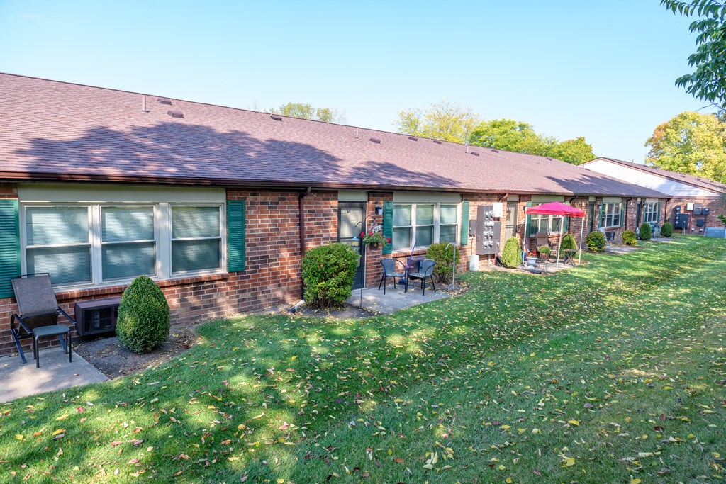 a view of the front of a brick house with a yard and grass