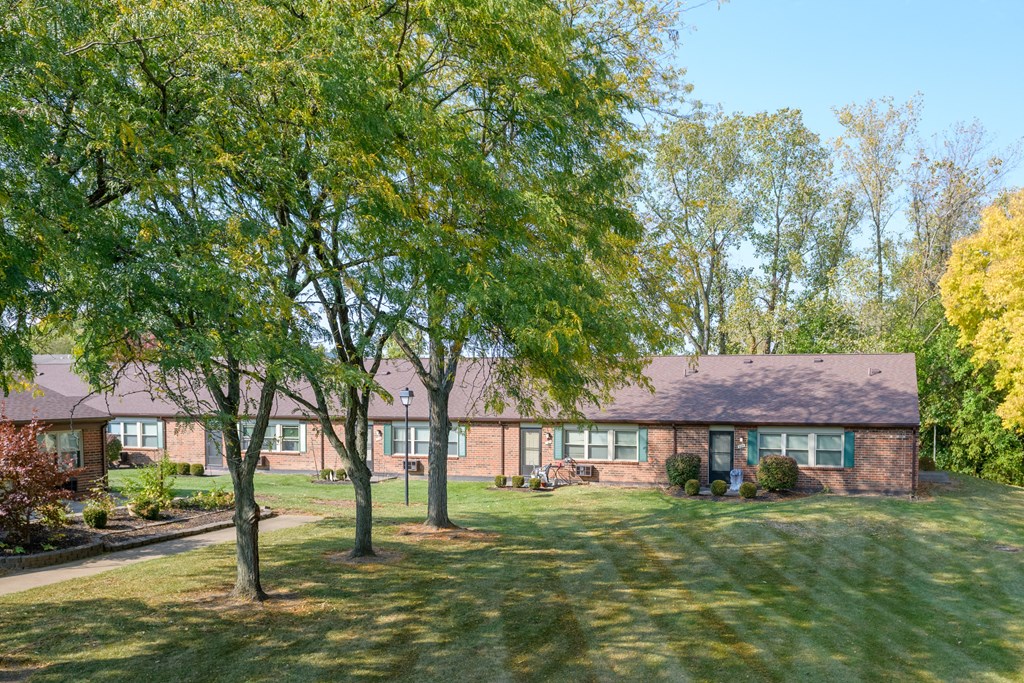 a large brick house with trees in front of it