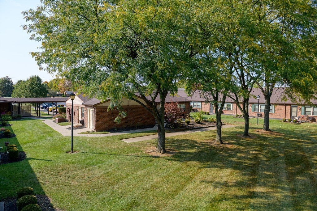 a view of the exterior of a brick building with trees