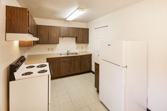 a kitchen with white appliances and wooden cabinets and a refrigerator