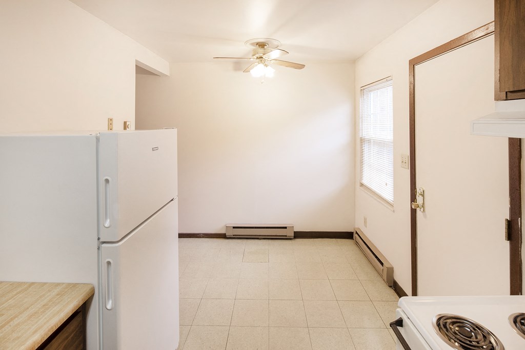 a kitchen with white appliances and a refrigerator  and a door to a room