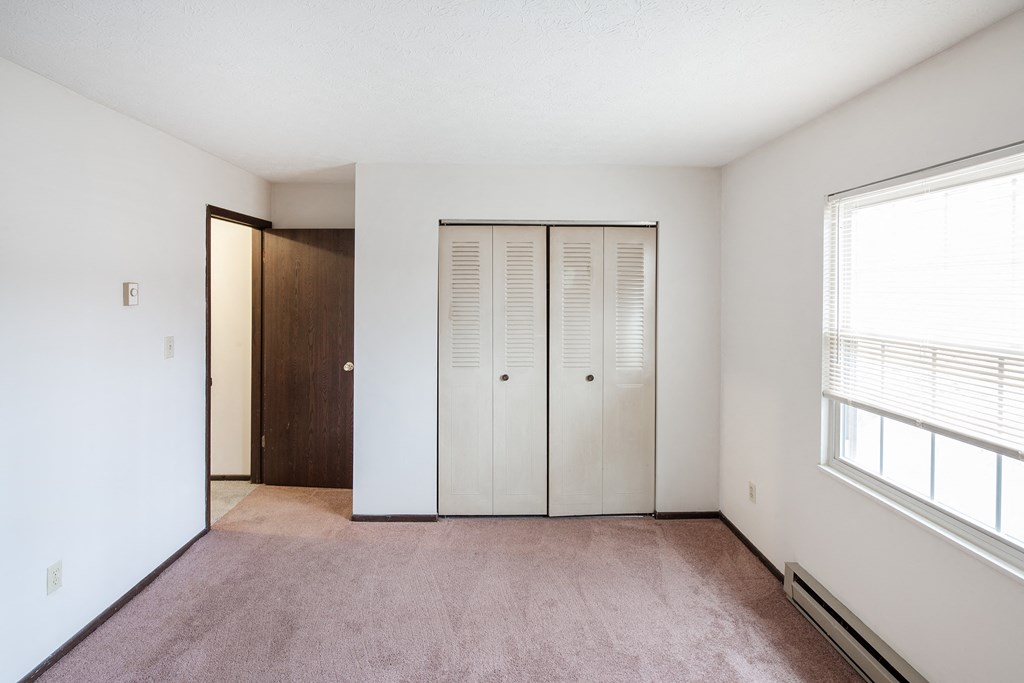 an empty living room with white walls and a closet