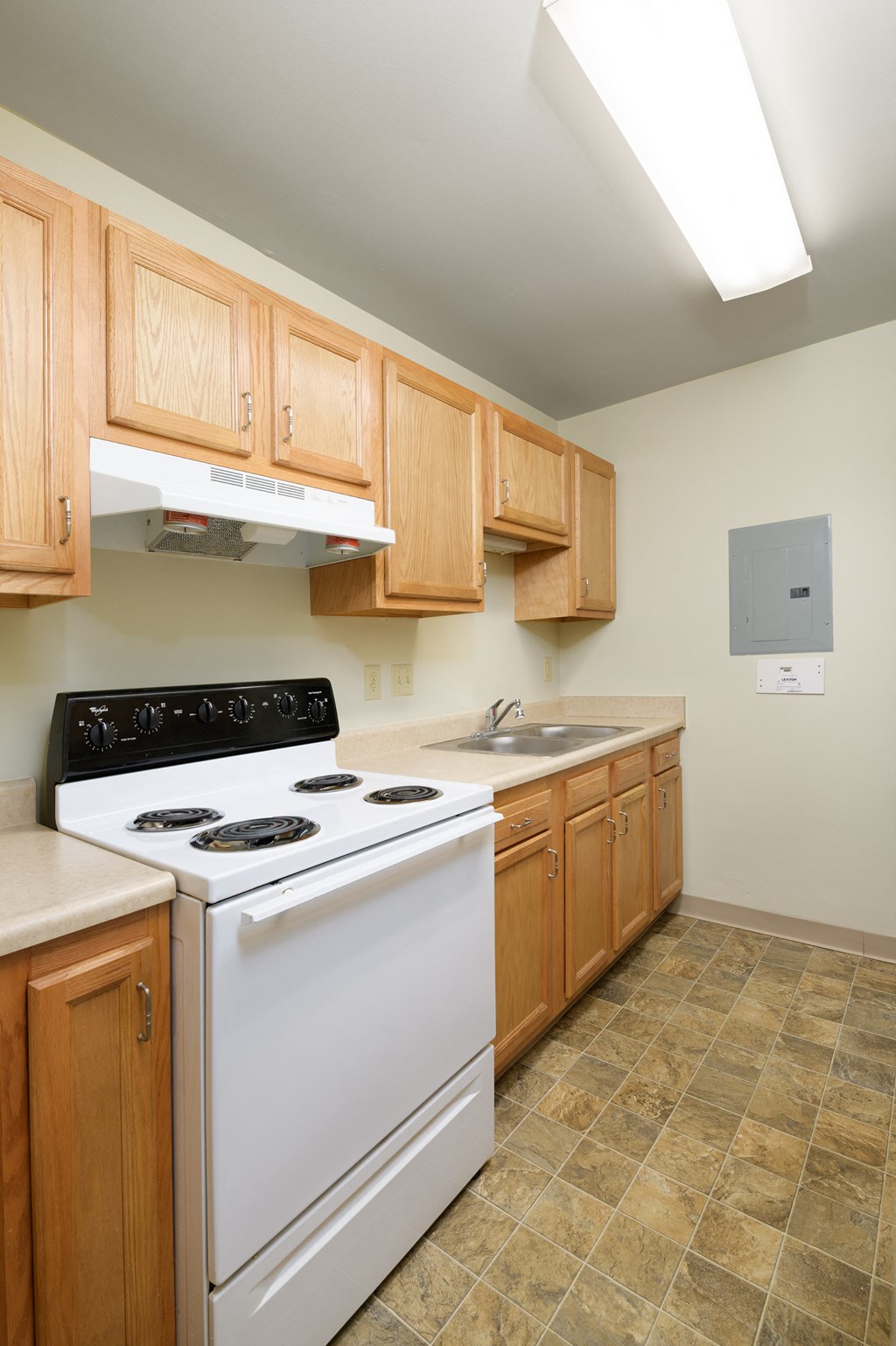 a kitchen with wood cabinets and a white stove top oven