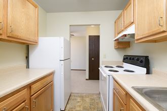 a kitchen with white appliances and wooden cabinets and a white refrigerator
