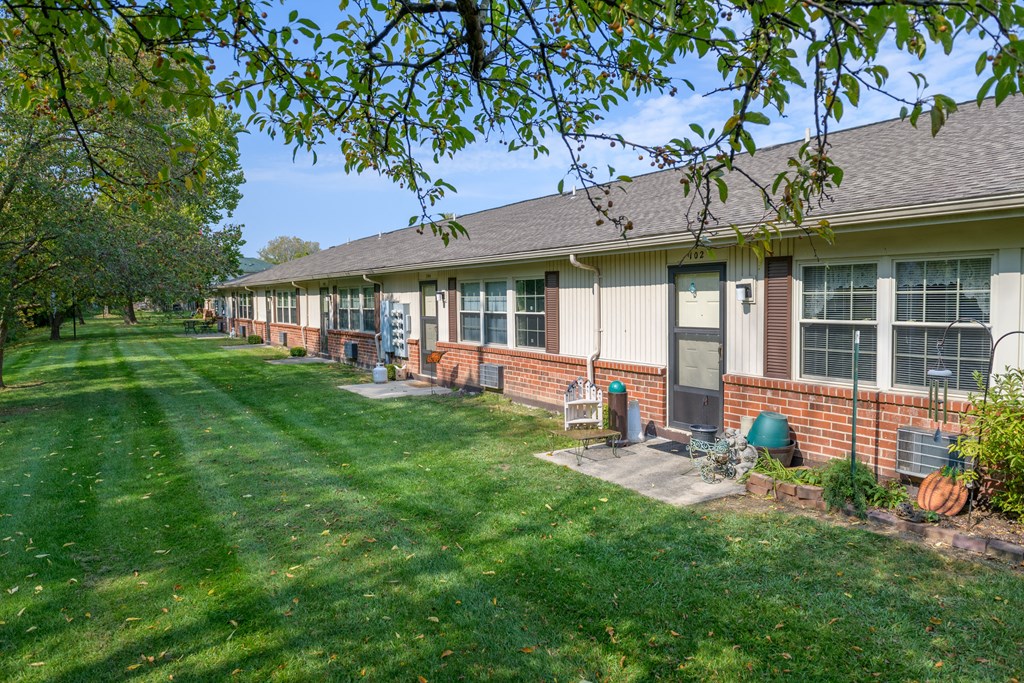 a row of houses with grass and trees in front of them