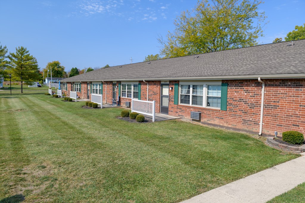 a brick building with a lawn and a sidewalk
