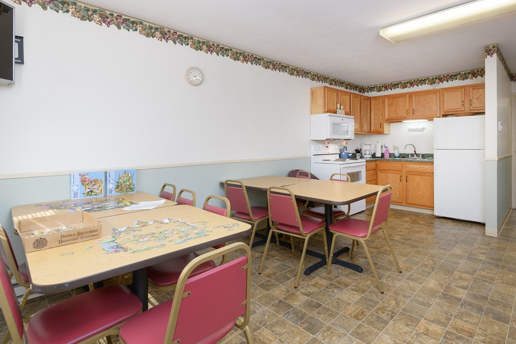 a dining room with a table and chairs and a kitchen