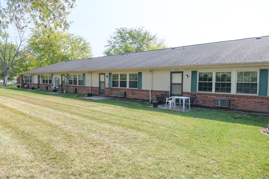 the front of a house with a lawn and a table