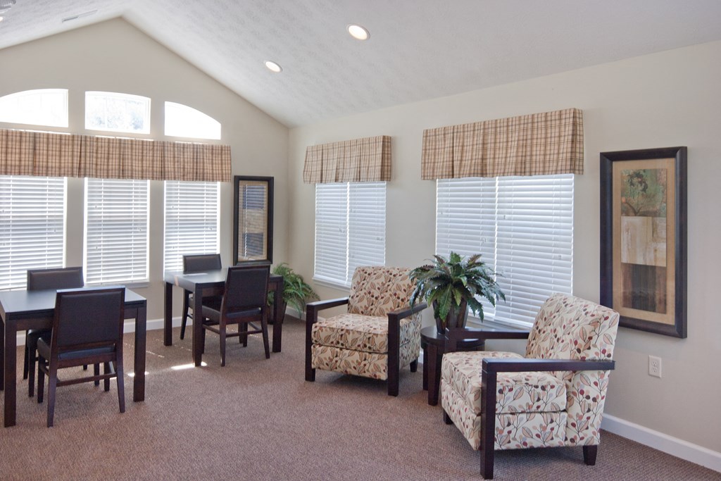 a living room with chairs and a dining room table
