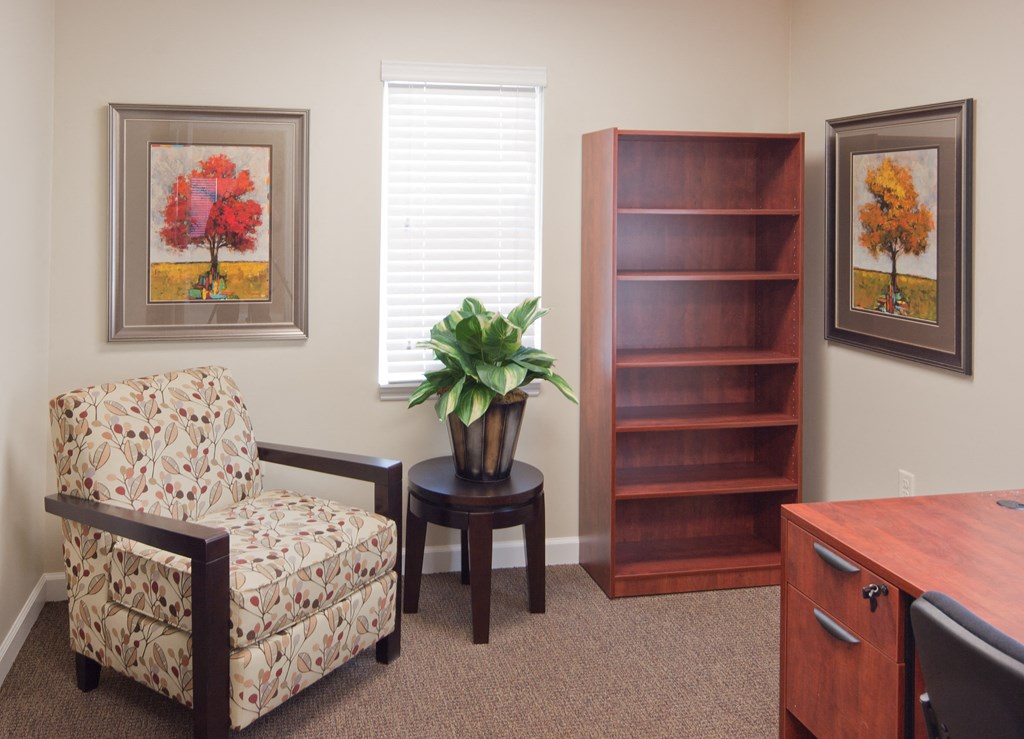 a living room with a chair and a plant on a table