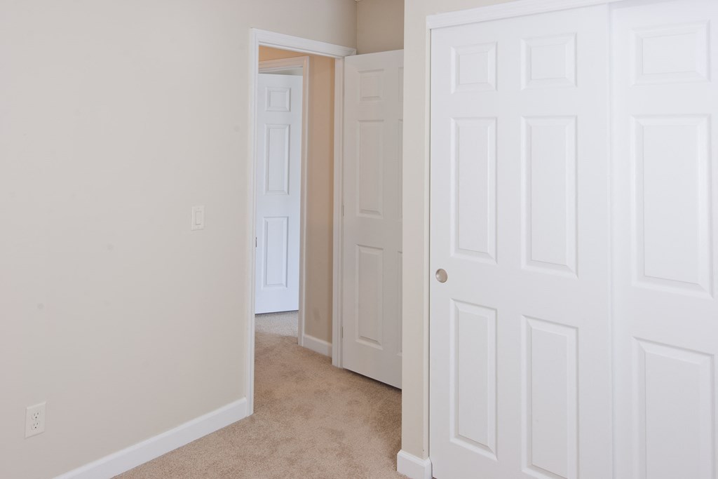 a bedroom with two closets and a door to a hallway
