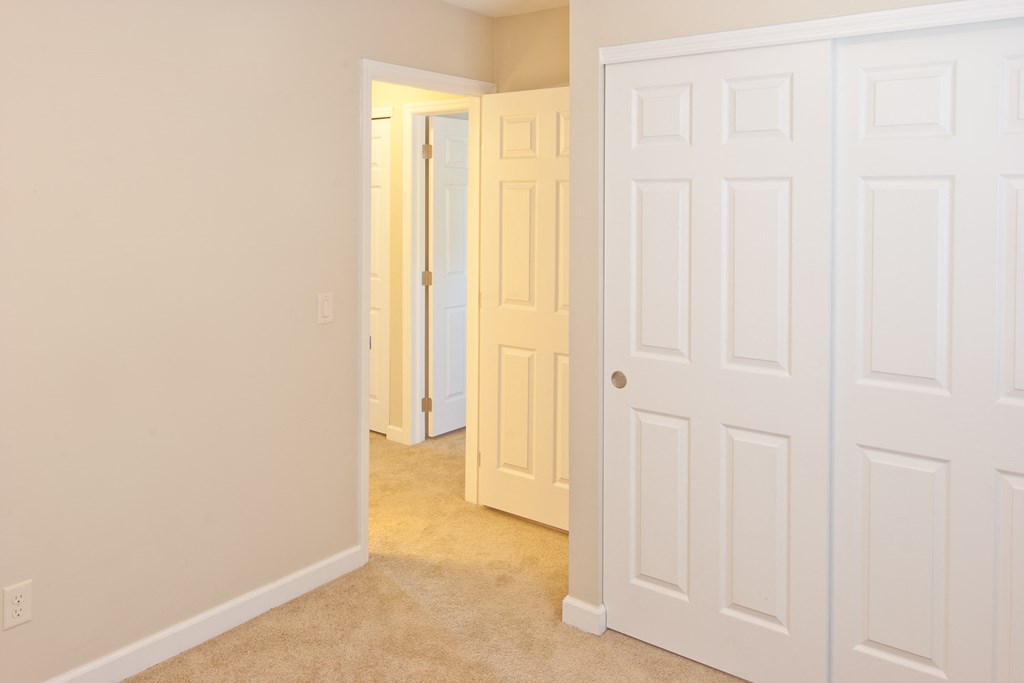 a bedroom with two closets and a door to a hallway