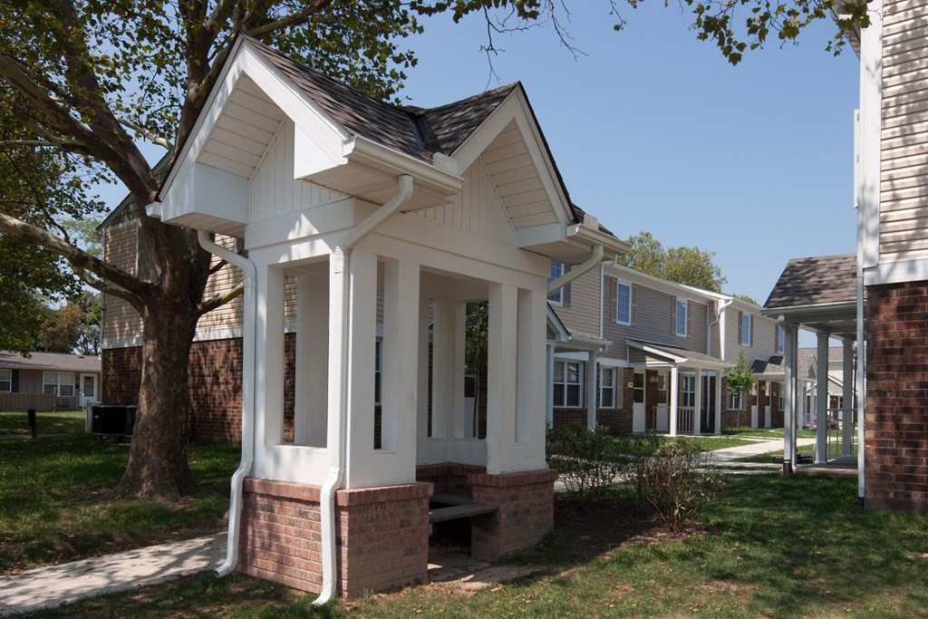 a small white house with a tree in front of it