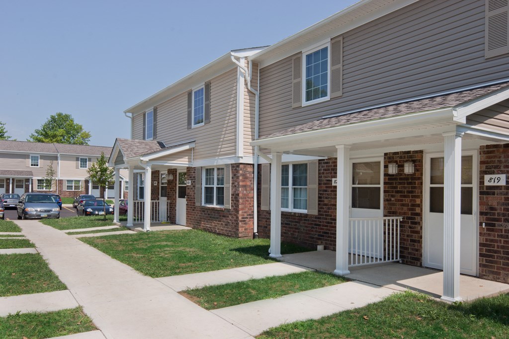 a row of houses with cars parked in front of them