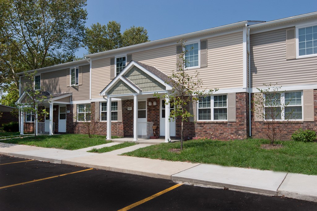 an apartment building with a sidewalk in front of it