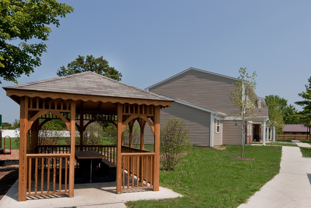 a gazebo with a house in the background