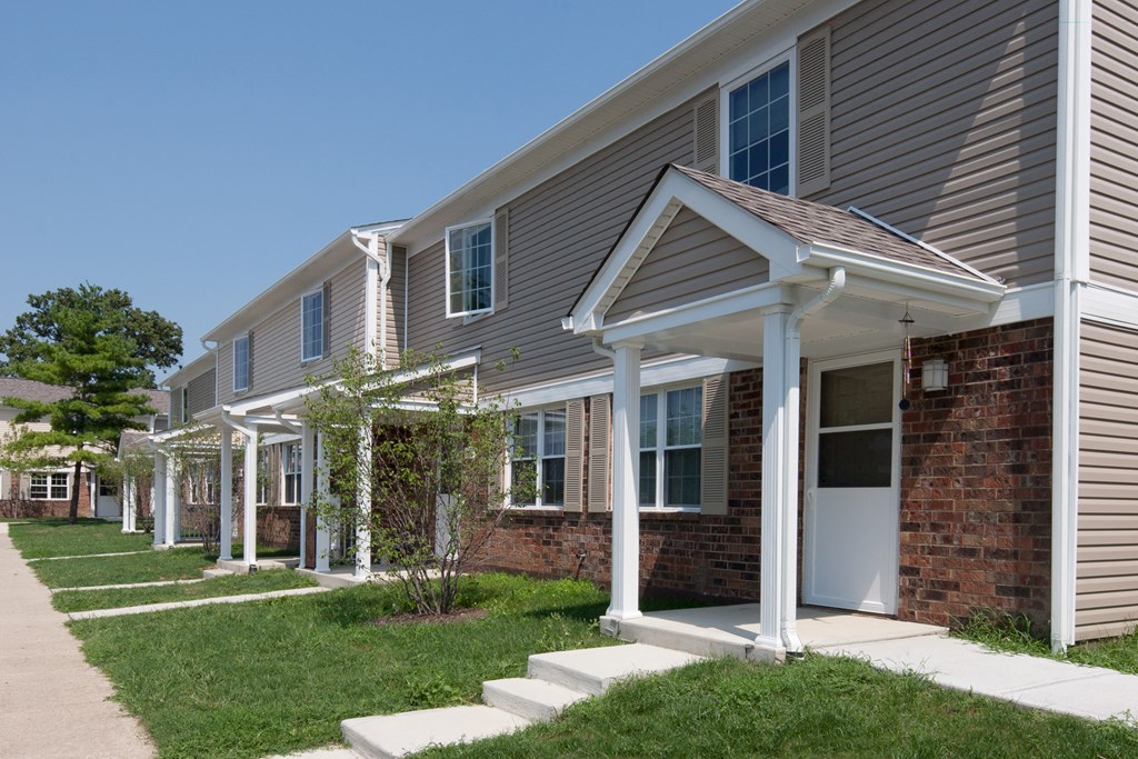 a row of houses with a sidewalk in front of them