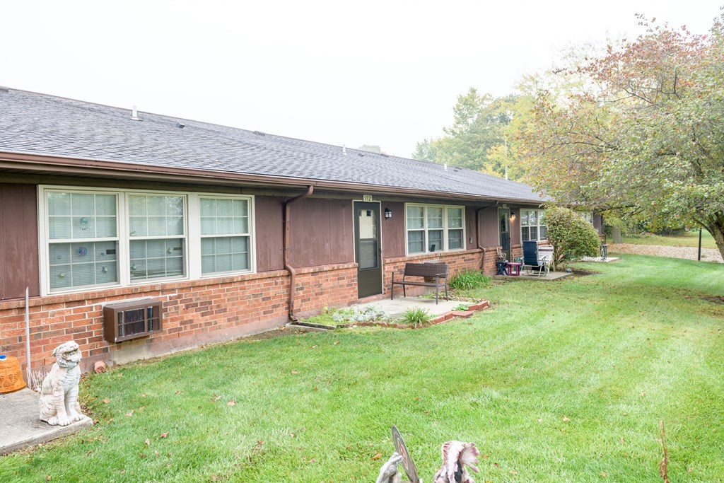 a dog standing in the yard in front of a house