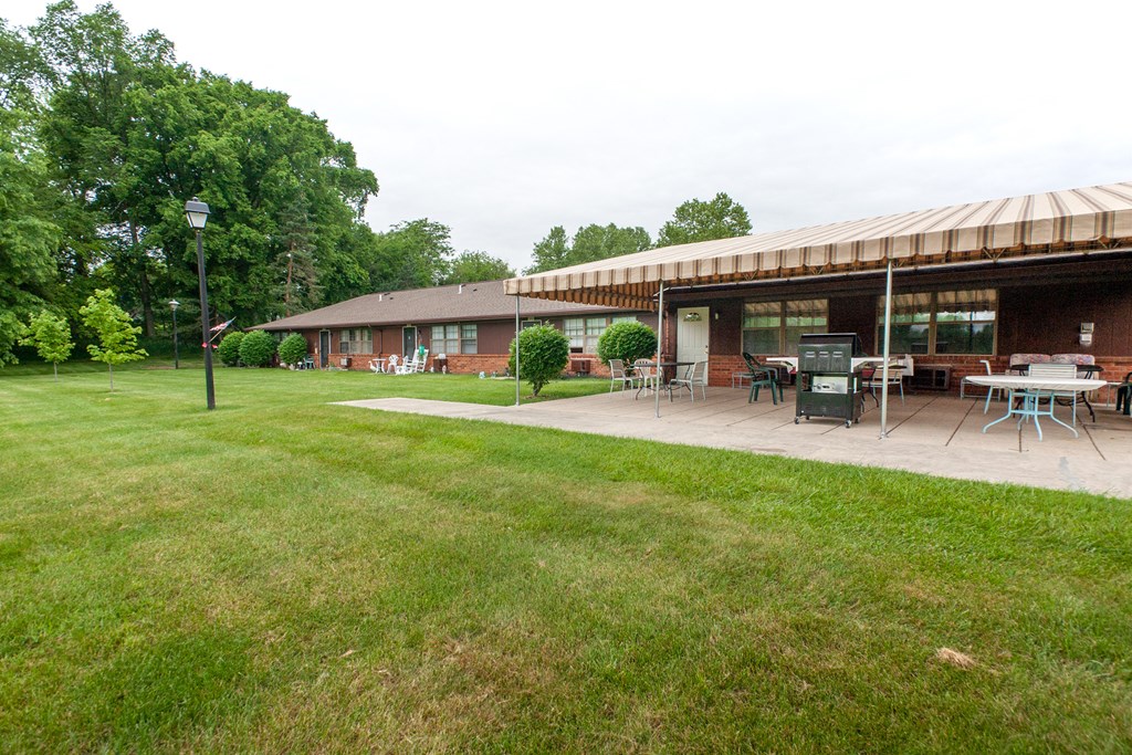 a patio with tables and chairs in front of a building