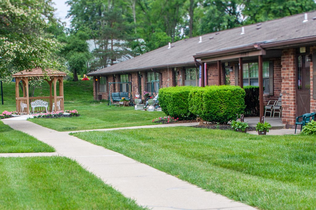 a house with a sidewalk and a gazebo in the yard