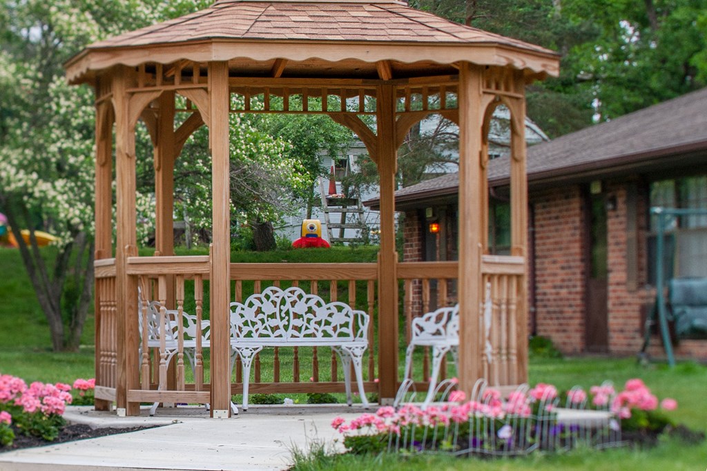 a gazebo with a table and chairs in a garden