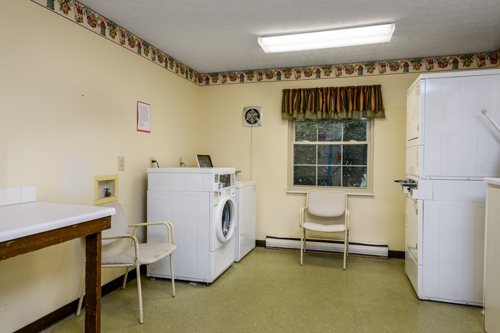 a laundry room with two washing machines and a table with chairs
