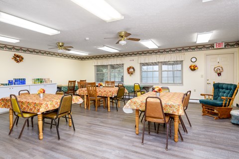 a dining room with tables and chairs and ceiling fans