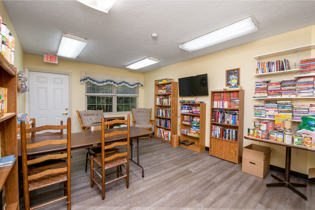 a library with a table and chairs and shelves of books