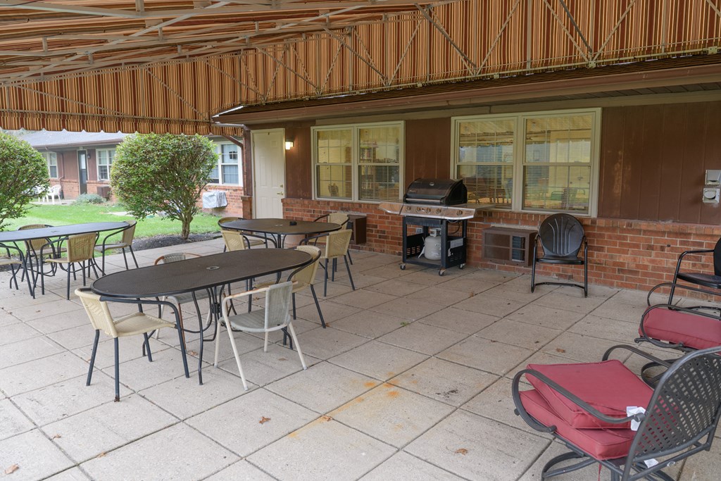 a covered patio with tables and chairs and a piano