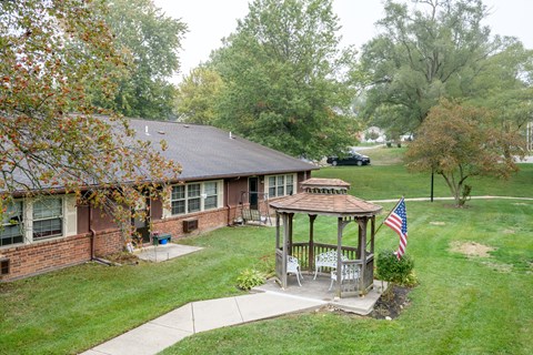 a house with a gazebo in the yard and a flag