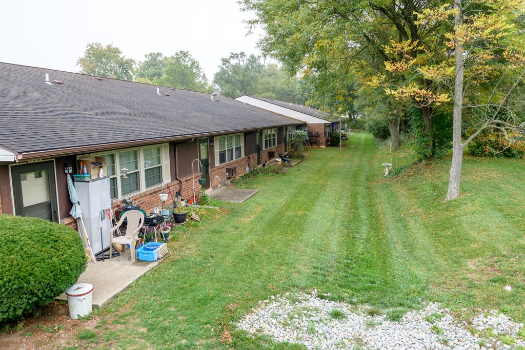 a view of the side of a house with a yard and a lawn