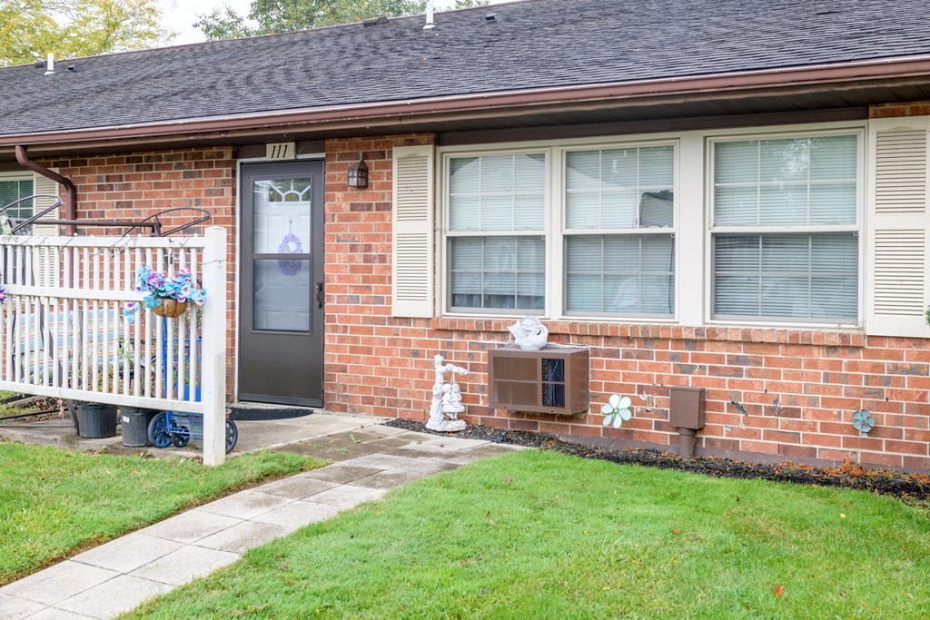a brick house with a porch and a blue door