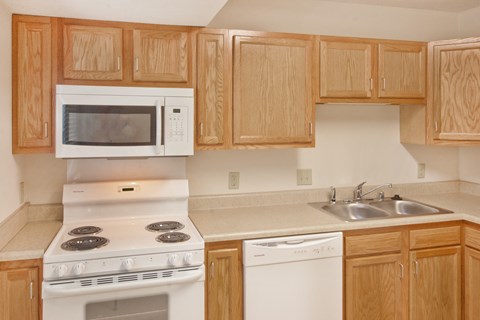 a kitchen with white appliances and wooden cabinets