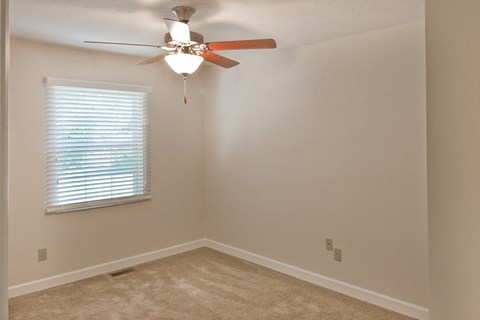 a bedroom with a ceiling fan and a window