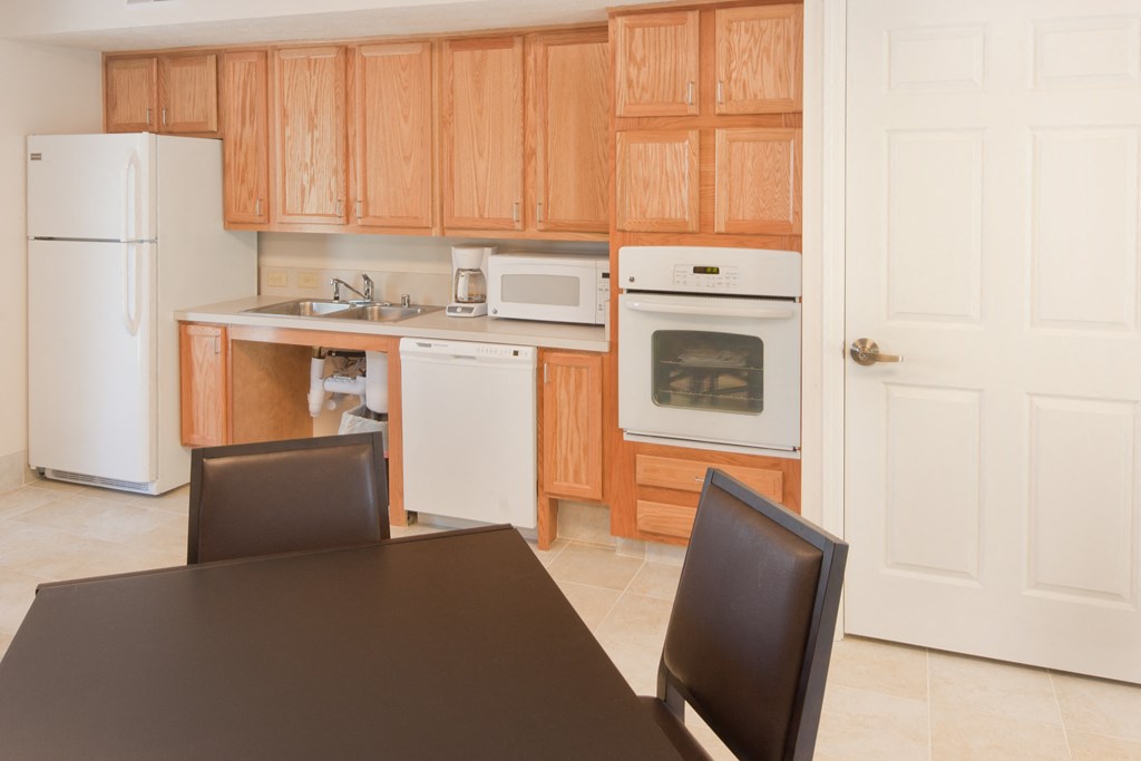 a kitchen with wooden cabinets and white appliances and a black table