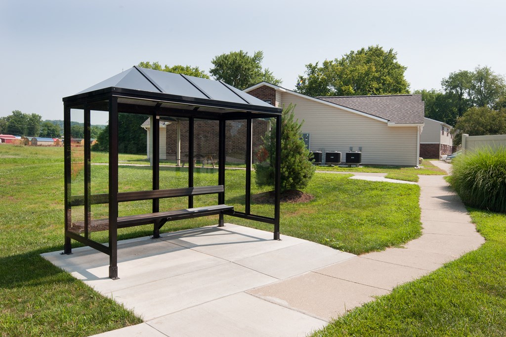 a gazebo with a sidewalk and a house in the background