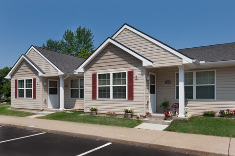 a white house with red shutters on the side of a street