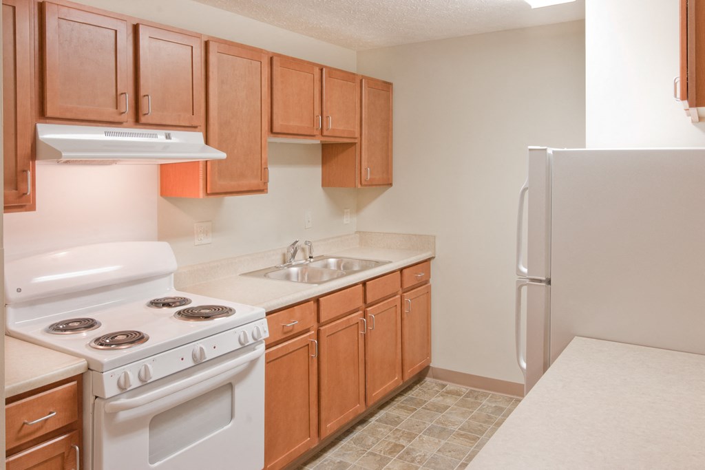 a kitchen with white appliances and wooden cabinets