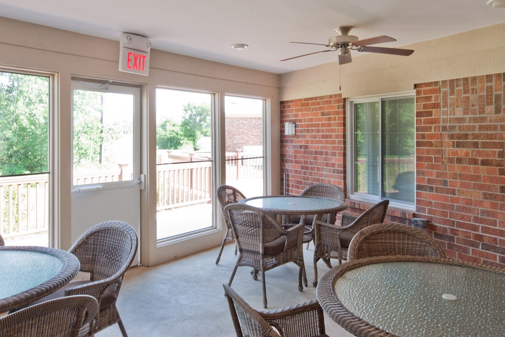 a patio with tables and chairs and a ceiling fan