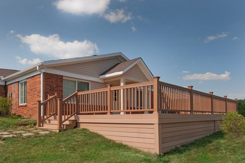 a wooden deck with a house in the background