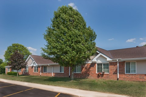 a brick house with a tree in front of it