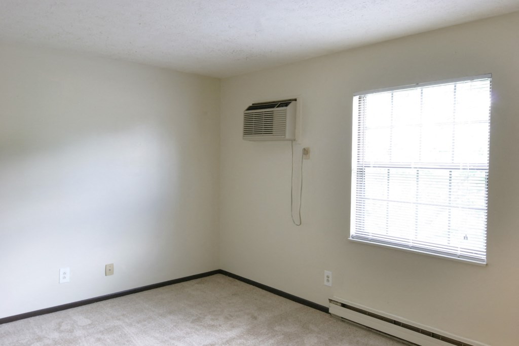 an empty room with an air conditioner and a window